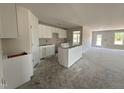 Bright kitchen featuring white cabinets, unfinished island and countertops, with an adjacent living area at 8 W Emily Gardens Dr, Selma, NC 27577