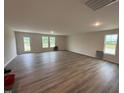 Spacious living room featuring wood-look floors, recessed lighting and large windows at 8 W Emily Gardens Dr, Selma, NC 27577