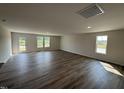 Spacious living room with dark wood floors, recessed lighting, and a back door to the outside at 8 W Emily Gardens Dr, Selma, NC 27577