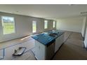 Open-concept kitchen features island with stainless appliances and abundant natural light at 82 W Emily Gardens Dr, Selma, NC 27576