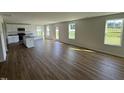 Open floor plan with wood floors and lots of windows and access to the kitchen with center island at 82 W Emily Gardens Dr, Selma, NC 27576
