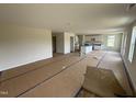 Open-concept living space with a view of a modern kitchen featuring white cabinets at 82 W Emily Gardens Dr, Selma, NC 27576