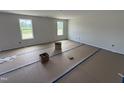 Spacious bedroom with large windows, neutral walls, and covered floors at 82 W Emily Gardens Dr, Selma, NC 27576