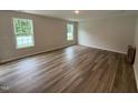 Bedroom featuring wood flooring, natural light from two windows, and neutral wall color at 83 W Emily Gardens Dr, Selma, NC 27576