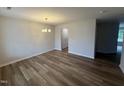 Bright dining room with wood flooring, modern chandelier, and neutral wall color at 83 W Emily Gardens Dr, Selma, NC 27576