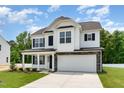 Inviting two-story home with a two-car garage, stone accents, and a manicured lawn at 83 W Emily Gardens Dr, Selma, NC 27576