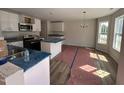 Eat-in kitchen features white cabinetry, a stainless steel range hood, and a view to the backyard at 83 W Emily Gardens Dr, Selma, NC 27576