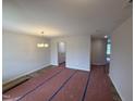 Spacious living room featuring contemporary chandelier, neutral walls, and hardwood floors at 83 W Emily Gardens Dr, Selma, NC 27576