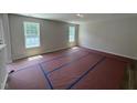Bright, unfurnished living room with new flooring, neutral paint, and abundant natural light from two windows at 83 W Emily Gardens Dr, Selma, NC 27576