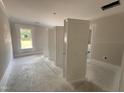Empty bedroom with bare concrete flooring and large window offering natural light at 87 Tee Dr, Selma, NC 27576