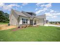 Well-manicured lawn and landscaping accentuate this charming home's side exterior and attached garage at 87 Tee Dr, Selma, NC 27576
