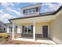 Inviting front porch with stone accents, white columns, and Craftsman-style details at 87 Tee Dr, Selma, NC 27576