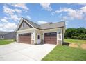 Spacious three-car garage featuring modern doors and exterior lighting at 87 Tee Dr, Selma, NC 27576