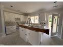 Bright, partially constructed kitchen with white cabinets, an island, and natural light at 87 Tee Dr, Selma, NC 27576