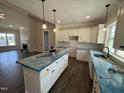 Modern kitchen with white cabinets, an island with pendant lighting, and an open layout at 87 Tee Dr, Selma, NC 27576