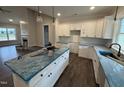 Modern kitchen with white cabinets, an island with a dark base, and lots of natural light at 87 Tee Dr, Selma, NC 27576