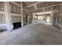 Large unfinished living room featuring fireplace and views into kitchen at 87 Tee Dr, Selma, NC 27576