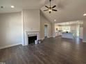 Spacious living room features a ceiling fan and a fireplace, with an open view into the modern kitchen at 87 Tee Dr, Selma, NC 27576