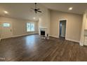Bright living room features a fireplace, modern ceiling fan, and wood-look floors at 87 Tee Dr, Selma, NC 27576