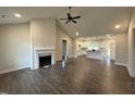 Open concept living room and kitchen area with a cozy fireplace and wood flooring at 87 Tee Dr, Selma, NC 27576