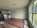 Open dining area featuring modern chandelier, large windows, and a glimpse into the kitchen at 89 W Emily Gardens Dr, Selma, NC 27576