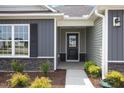 Inviting front entrance featuring well manicured landscaping and neutral siding at 89 W Emily Gardens Dr, Selma, NC 27576