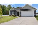 Charming single-story home boasts a well-manicured lawn and attached two-car garage at 89 W Emily Gardens Dr, Selma, NC 27576