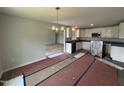Open-concept kitchen with white cabinets and new appliances, seamlessly connected to the dining area at 89 W Emily Gardens Dr, Selma, NC 27576