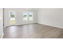 Bright living room featuring wood-look floors, a white wall paint, and natural light at 89 W Emily Gardens Dr, Selma, NC 27576