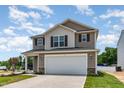 Charming two-story home showcasing a two-car garage, neutral siding, and a well-manicured front lawn at 9 W Emily Gardens Dr, Selma, NC 27576