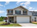 Charming two-story home showcasing a two-car garage, neutral siding, and a well-manicured front lawn at 9 W Emily Gardens Dr, Selma, NC 27576