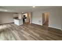 Open-concept kitchen and living area featuring white cabinets, wood-look flooring, and modern appliances at 9 W Emily Gardens Dr, Selma, NC 27576