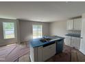 Bright kitchen with a central island featuring a sink, white cabinets, and stainless steel dishwasher at 9 W Emily Gardens Dr, Selma, NC 27576