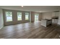 Open concept living area featuring wood-look flooring, bright windows, and a kitchen island with gray countertops at 9 W Emily Gardens Dr, Selma, NC 27576