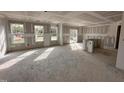 Spacious living room featuring drywall, multiple windows for ample natural light, and a walkout to the backyard at 9 W Emily Gardens Dr, Selma, NC 27576