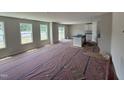 Bright and spacious living room featuring multiple windows, open space, and an adjacent kitchen area at 9 W Emily Gardens Dr, Selma, NC 27576