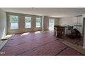 Spacious living room featuring large windows for abundant natural light and a partial view of the kitchen at 9 W Emily Gardens Dr, Selma, NC 27576