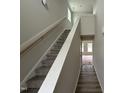 Bright entryway showcasing carpeted stairs, a wooden handrail, and an opening leading to the main living area at 9 W Emily Gardens Dr, Selma, NC 27576