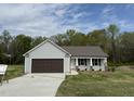 Newly constructed single-story home with brown two-car garage and gray siding at 91 Harvest Hills Ln, Dunn, NC 28334