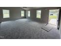 A spacious living room with new carpet, large windows, and ample natural light at 91 Harvest Hills Ln, Dunn, NC 28334