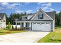 Well-manicured one-story home showcasing a two-car garage and an inviting front yard at 98 Laramie Ln, Selma, NC 27576