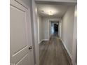 Inviting hallway with elegant wood flooring and neutral paint, leading to a living area at 98 Laramie Ln, Selma, NC 27576