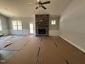 Bright living area with stone fireplace, ceiling fan, and trim details at 98 Laramie Ln, Selma, NC 27576