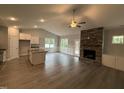 Open concept living room with stone fireplace, and open to the kitchen and dining area at 98 Laramie Ln, Selma, NC 27576