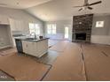 Open concept living space with a stone fireplace, ceiling fan, and island with seating at 98 Laramie Ln, Selma, NC 27576