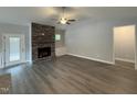Spacious living room featuring a stone fireplace, ceiling fan, and wood-look floors at 98 Laramie Ln, Selma, NC 27576
