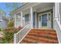 Inviting covered front porch with brick steps and white railings, perfect for relaxing at 101 Elk River Ct. Ct, Mebane, NC 27302