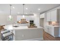 Bright kitchen showcasing an oversized island, stainless steel appliances, and white cabinetry at 102 E Star Foal Ln, Wendell, NC 27591