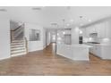 Open-concept living space featuring a modern kitchen, hardwood floors, and staircase at 102 E Star Foal Ln, Wendell, NC 27591