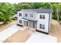Aerial view of a gray duplex with modern design, set among mature trees and manicured landscaping at 1047 |1049 E Harnett St, Dunn, NC 28334